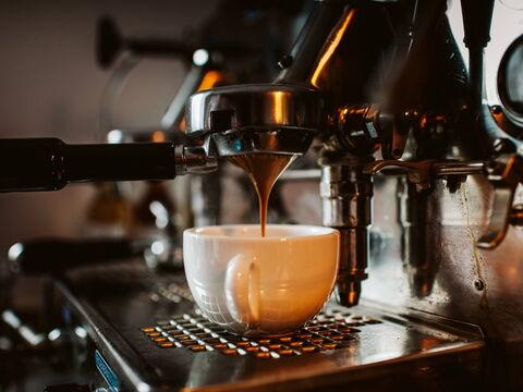 Espresso läuft aus einem Siebträger in eine weiße Porzellantasse