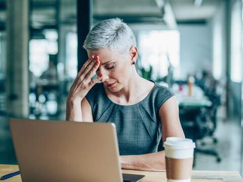 Frau hat Kopfschmerzen im Büro