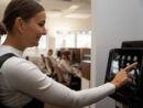 Mitarbeiterin Natali Stockhowe zieht sich einen Kaffee am Vollautomaten im Büro