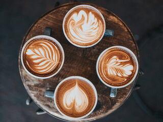 Vier Tassen nebeneinander mit kreativer Latte Art