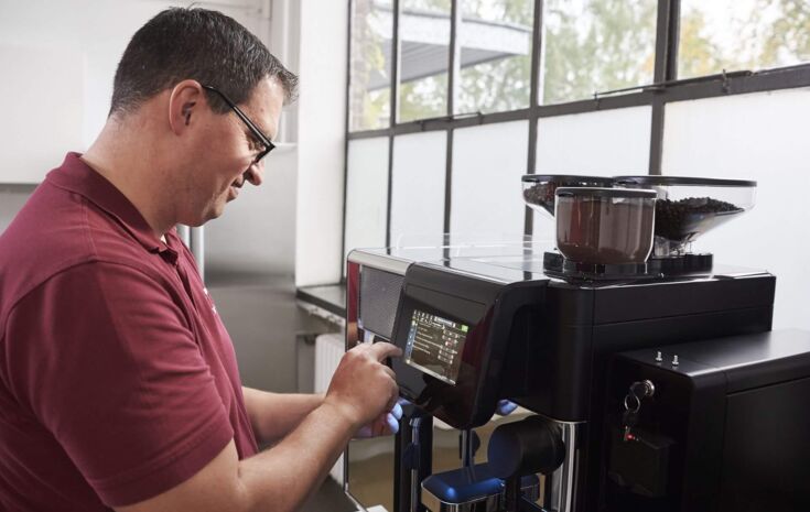 Werkstatt-Mitarbeiter von Kaffee Partner repariert Maschine