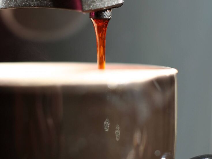 Kaffee läuft in Kaffeetasse aus einer Kaffeemmaschine