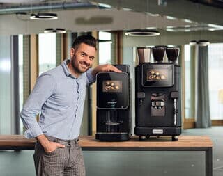 Junger Mann präsentiert die Modelle Barista Select und Barista Ultima