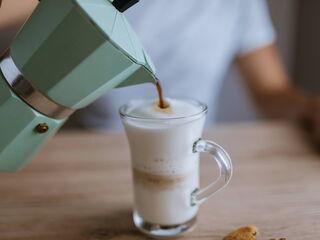 Espresso wird in aufgeschäumte Milch gegossen