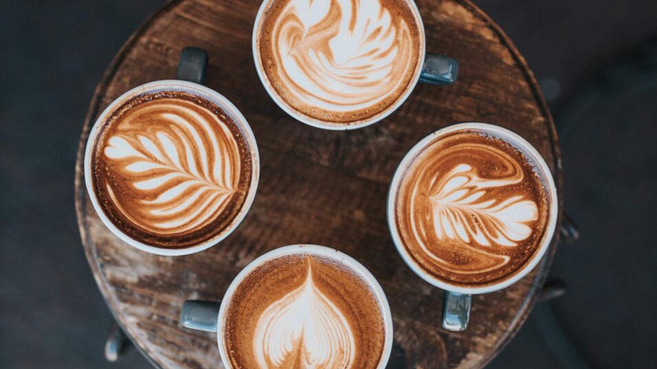 Vier Tassen nebeneinander mit kreativer Latte Art
