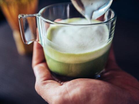 Mann hält Matcha Latte in Hand