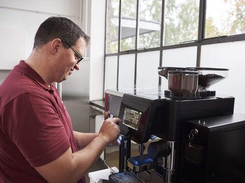 Werkstatt-Mitarbeiter von Kaffee Partner repariert Maschine