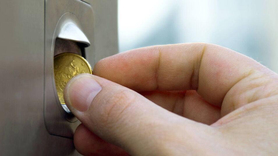 Münze wird durch Schlitz in den Automaten eingeworfen.