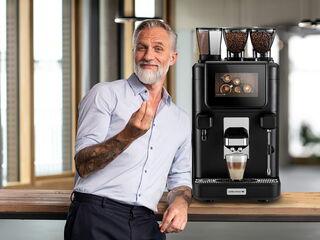 Mann mittleren Alters präsentiert Kaffeevollautomaten