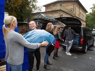 Menschenreihe die einen blauen Sack weiterreicht