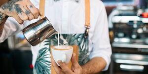 Barista arbeitet an der Bar und bereitet Latte-Art vor