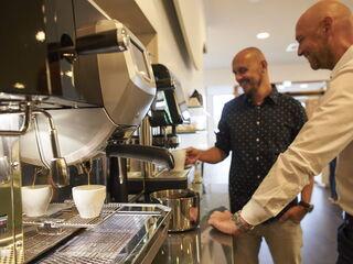 Kollege zieht sich Kaffee am Automaten