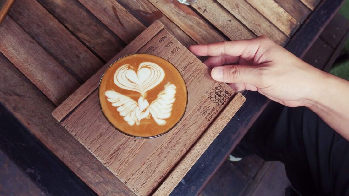 Kaffeetasse mit Latte Art Flügel und Herz