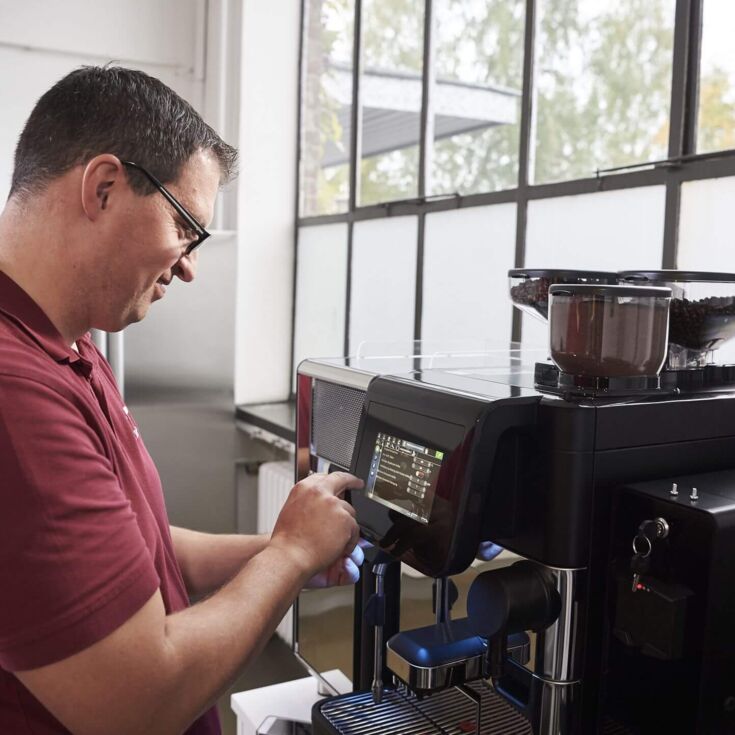 Kaffee Partner's workshop employee fixes machine