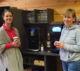 Two colleagues enjoy a coffee break next to a fully automatic coffee machine and water dispenser in the AWEWA-Coaching office