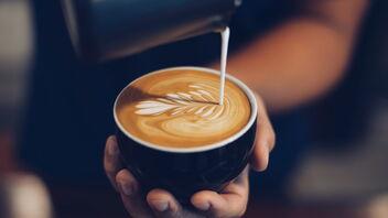 Barista verziert Cappuccino mit Latte Art