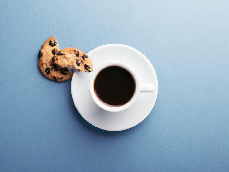 Schwarzer Kaffee serviert mit einem Cookie auf einer Untertasse