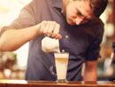 Mann gießt Espresso in Latte macchiato