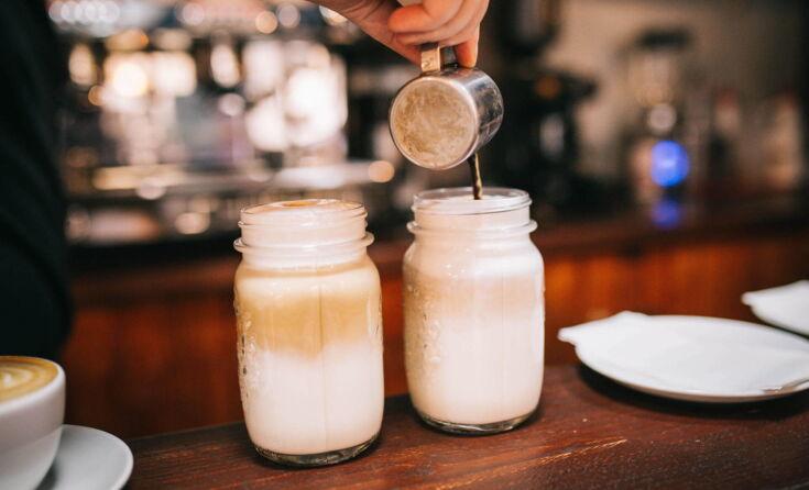 Milchkaffee in glaesern auf einem holztisch