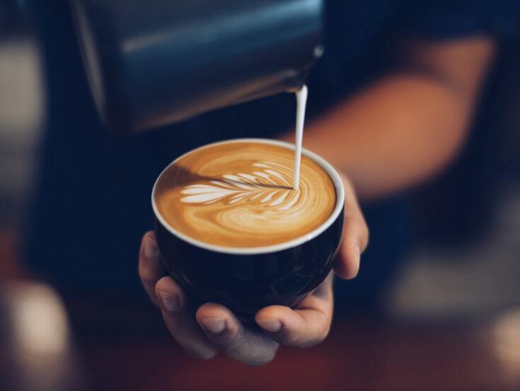 Barista verziert Cappuccino mit Latte Art